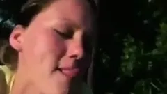 She sucks dick outdoors and eats cum out of a condom