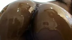 Tanned cougar gets a lot of oil for her ass and tastes big schlong