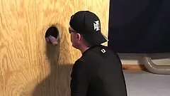 Gay hunk sucks on a stranger's rock-hard jackhammer through a glory hole