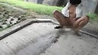 Mature Asian lady is outside virtually naked taking a piss