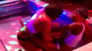 Women stripping one another oil wrestling