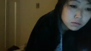 Young Asian brunette FredFreeload lies in bed to participat