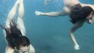 Julia and Masha are swimming nude in the sea