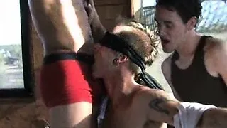 Two college boys play with another college boy on a sling.