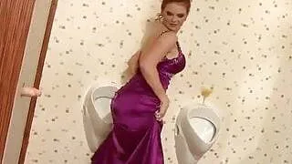 Busty redhead has fun at the gloryhole