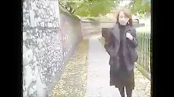 Woman pissing in a stone wall