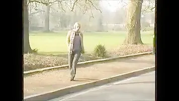 Woman pissing in a wooden fence