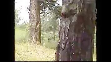 Redhead girl peeing behind a tree