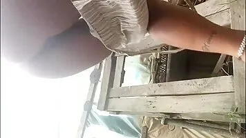 Girl with a tattoo on her lower back pooping outdoor