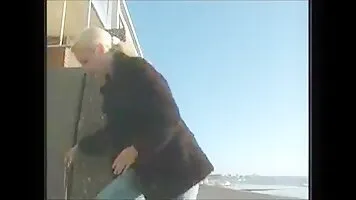 Blonde pissing on the doorstep by the sea