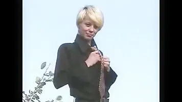 Blonde with short hair pissing on the street