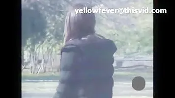 Peeing beside a tree while waiting for a train